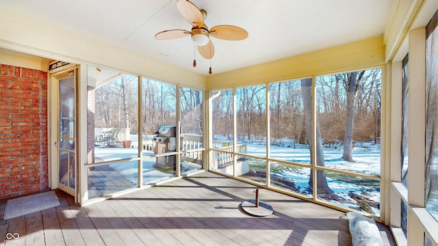 unfurnished sunroom with ceiling fan