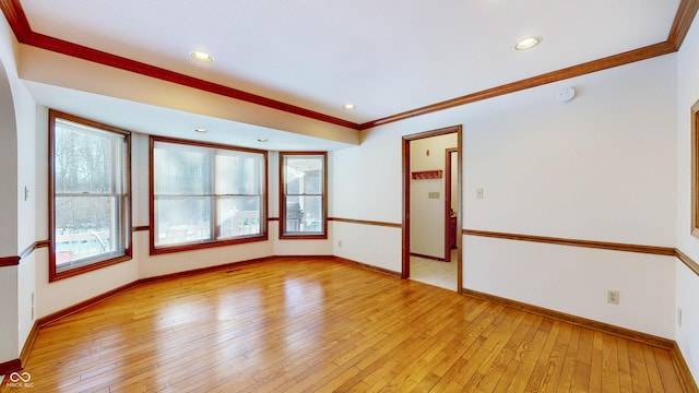 unfurnished room featuring crown molding, a healthy amount of sunlight, and light hardwood / wood-style flooring