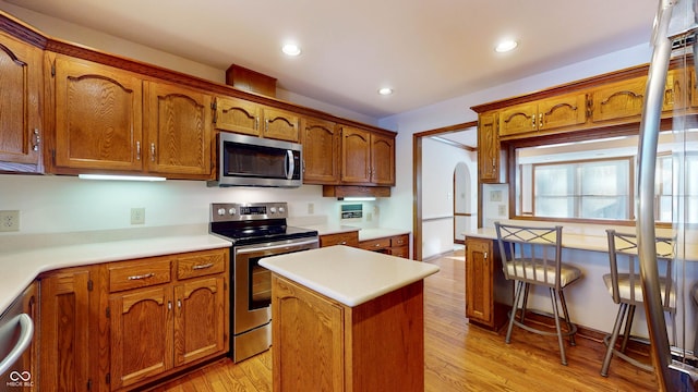 kitchen featuring stainless steel appliances, a center island, and light hardwood / wood-style flooring