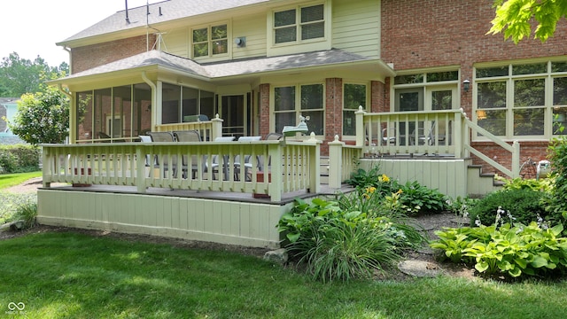 back of property featuring a yard and a sunroom