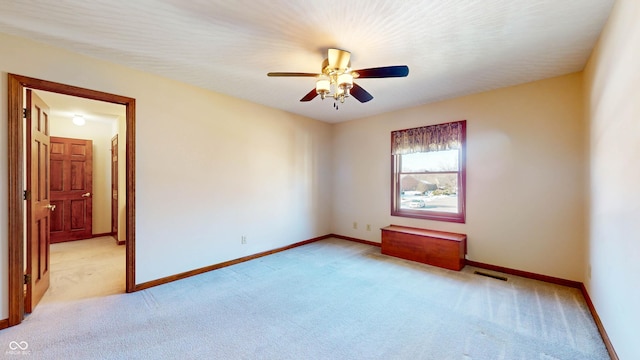 unfurnished room featuring ceiling fan and light colored carpet