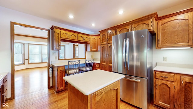 kitchen featuring stainless steel refrigerator, a center island, and light hardwood / wood-style flooring