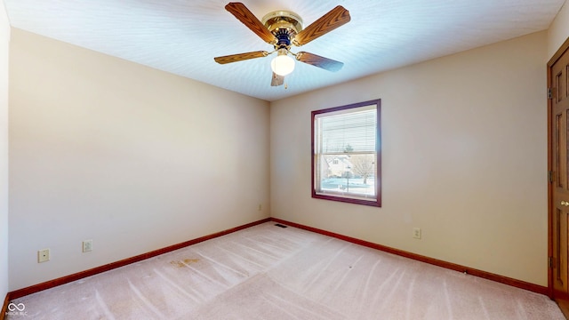 carpeted spare room featuring ceiling fan