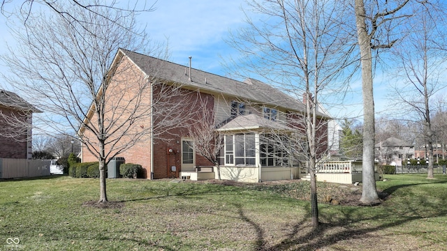 view of side of property featuring a sunroom and a yard