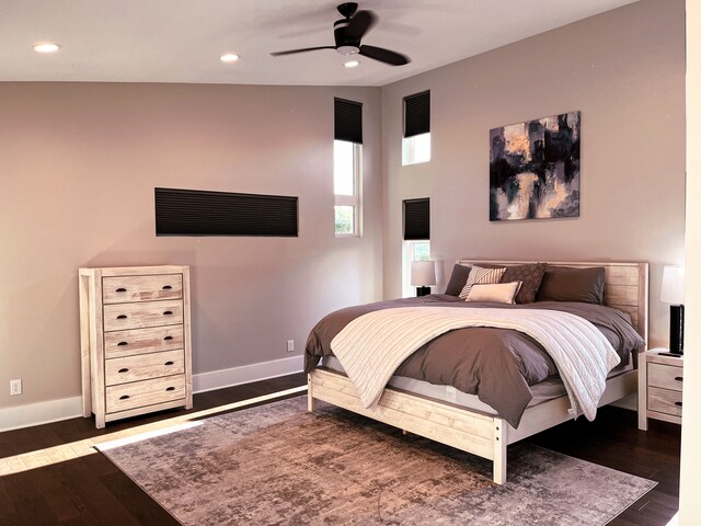 bedroom with ceiling fan, dark wood-type flooring, and lofted ceiling