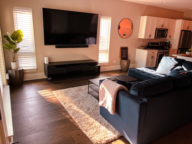 living room with plenty of natural light and dark wood-type flooring