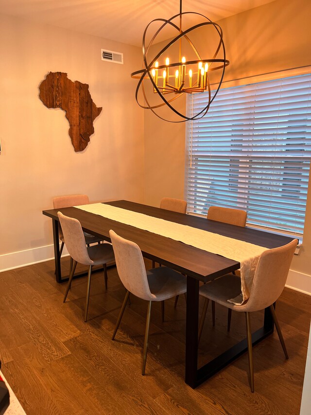 dining space with dark hardwood / wood-style floors and an inviting chandelier