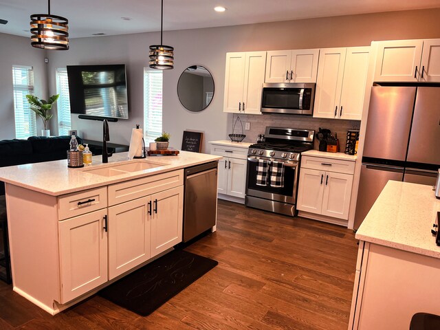 kitchen featuring dark hardwood / wood-style floors, pendant lighting, sink, stainless steel appliances, and tasteful backsplash