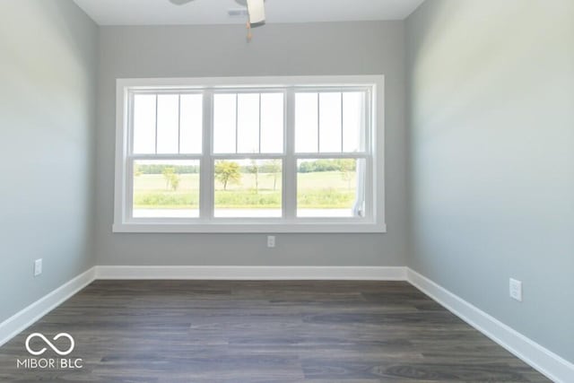 spare room with dark wood-type flooring, ceiling fan, and a wealth of natural light