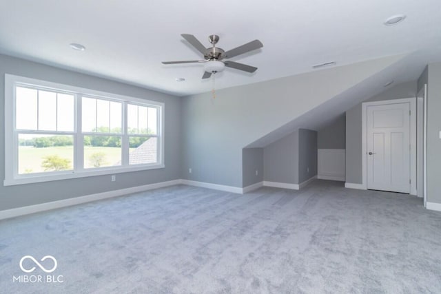 additional living space with vaulted ceiling, light colored carpet, and ceiling fan