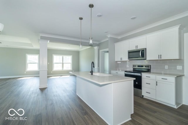 kitchen with appliances with stainless steel finishes, sink, hanging light fixtures, and white cabinets