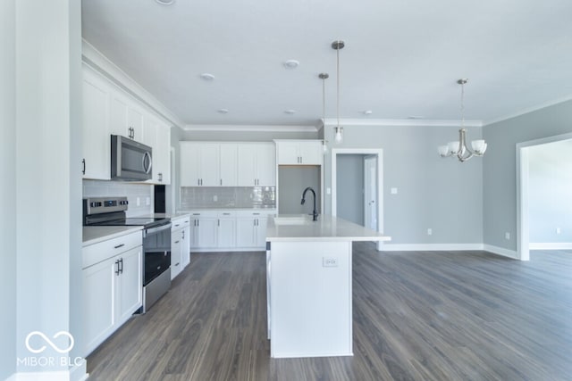 kitchen with dark hardwood / wood-style floors, tasteful backsplash, stainless steel appliances, decorative light fixtures, and a kitchen island with sink