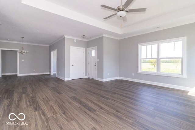 interior space with dark hardwood / wood-style floors, ceiling fan with notable chandelier, a tray ceiling, and crown molding