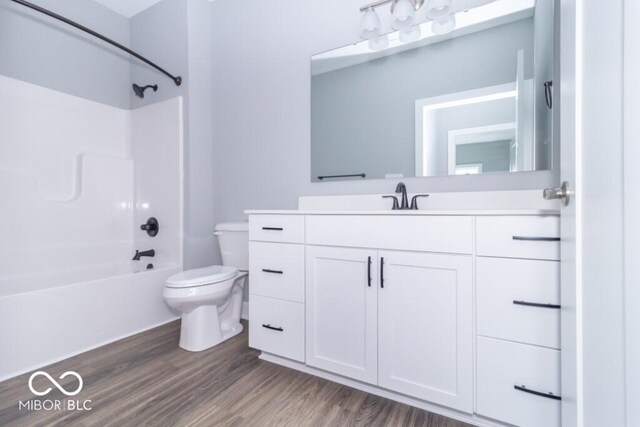 full bathroom with shower / tub combination, large vanity, toilet, and wood-type flooring