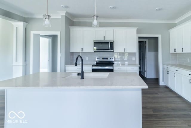 kitchen featuring hanging light fixtures, stainless steel appliances, white cabinets, and a center island with sink