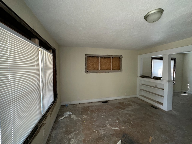 empty room featuring a textured ceiling and a wealth of natural light