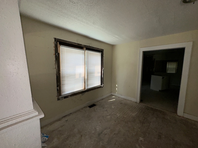 spare room with a textured ceiling