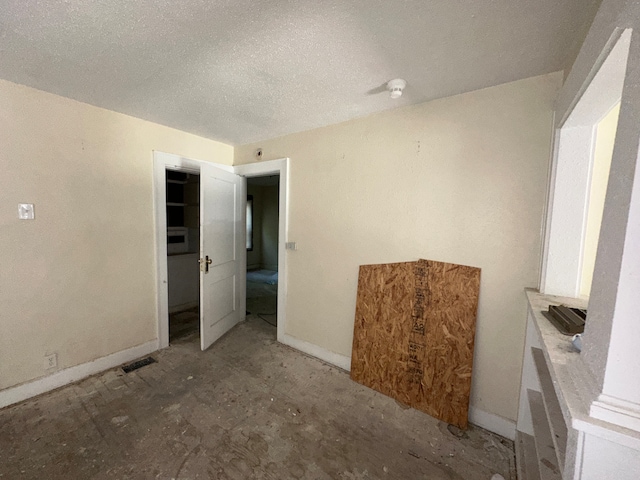 unfurnished room with a textured ceiling