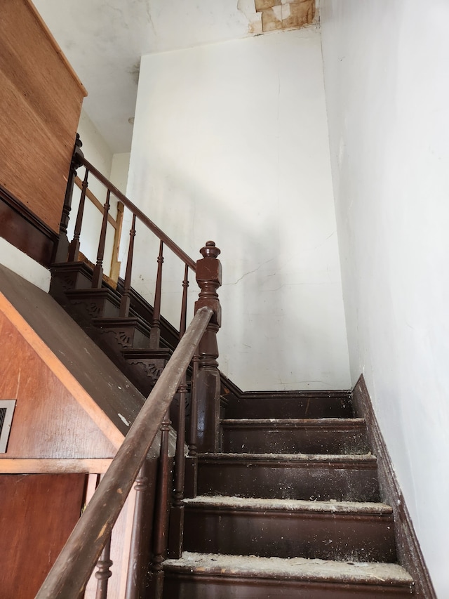 stairway featuring a towering ceiling