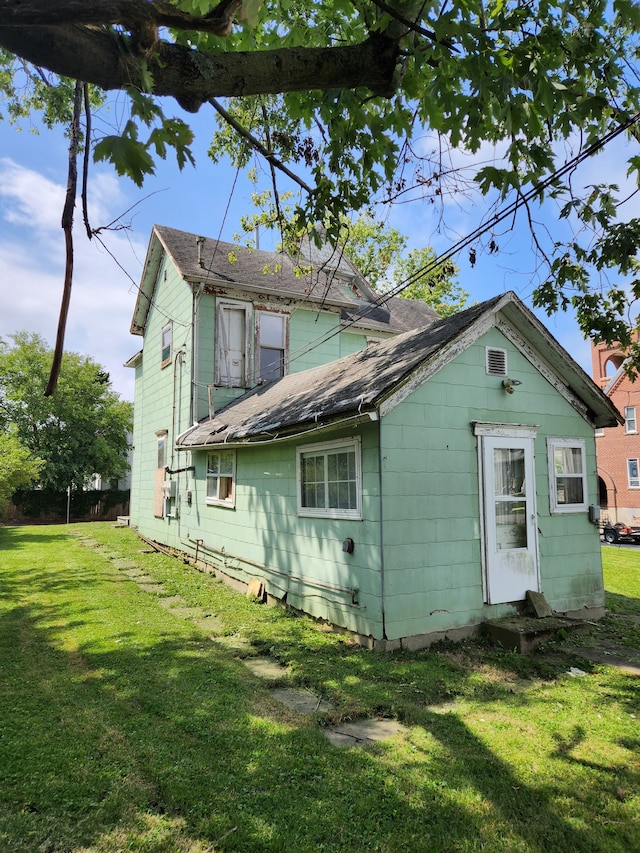 rear view of property featuring a yard