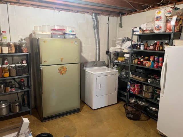 basement featuring washer / clothes dryer and white refrigerator