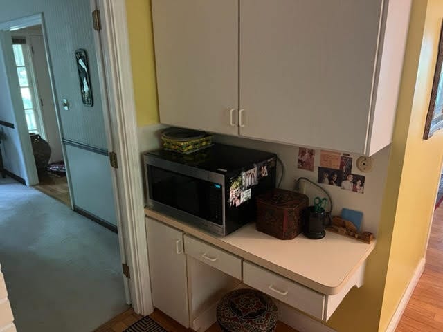 kitchen with light hardwood / wood-style floors and white cabinets