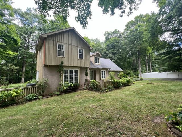 rear view of house featuring a lawn