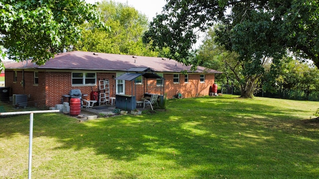 back of house with a yard and central air condition unit