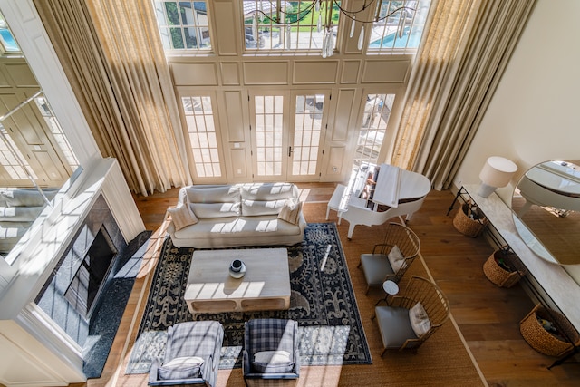 living room featuring a notable chandelier, wood-type flooring, and a high ceiling