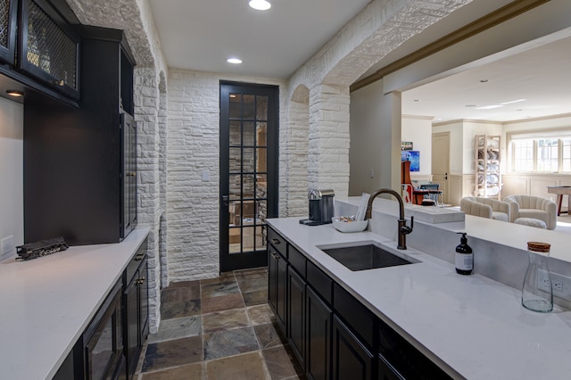 kitchen featuring dark tile flooring, crown molding, black microwave, and sink