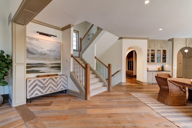 entrance foyer with ornamental molding and light wood-type flooring