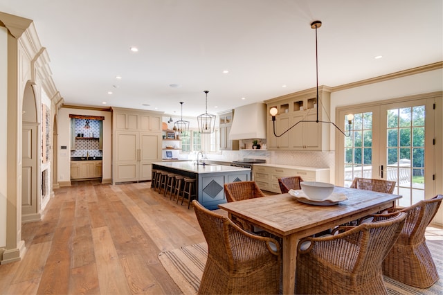 dining area with light hardwood / wood-style flooring, sink, plenty of natural light, and french doors