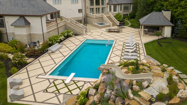 view of pool featuring a gazebo, a patio, a diving board, a yard, and a water slide