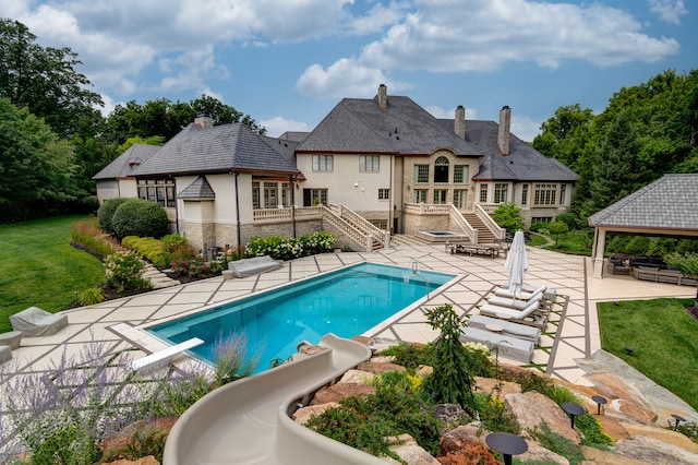 view of swimming pool with a gazebo, a water slide, a diving board, a patio, and a lawn