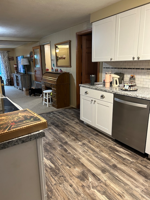 kitchen featuring light stone countertops, white cabinets, stainless steel dishwasher, tasteful backsplash, and dark hardwood / wood-style flooring