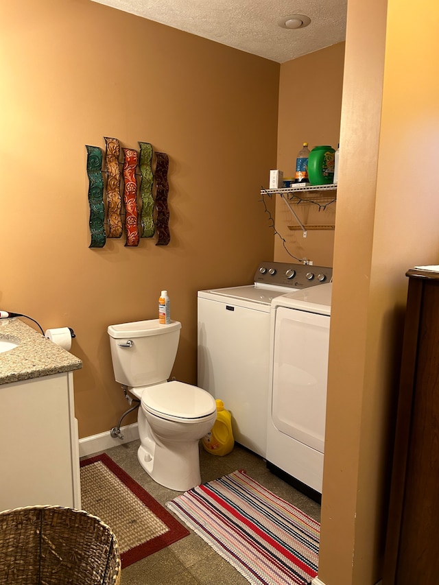 bathroom with washer and dryer, toilet, a textured ceiling, and vanity