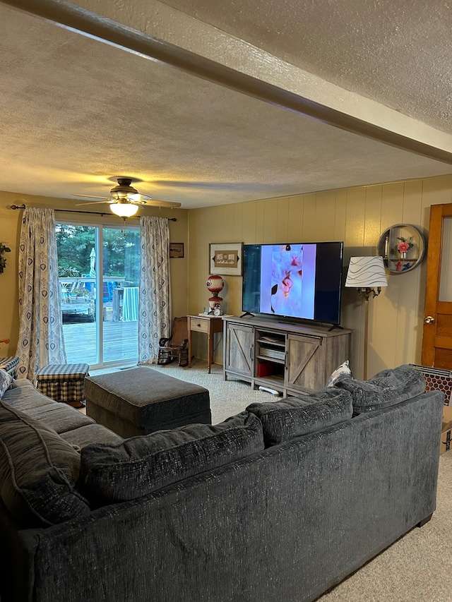 carpeted living room featuring a textured ceiling and ceiling fan