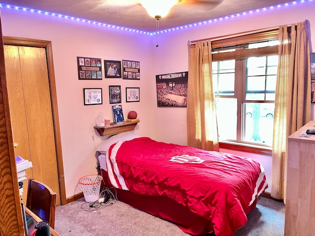 bedroom with carpet flooring, a textured ceiling, and ceiling fan