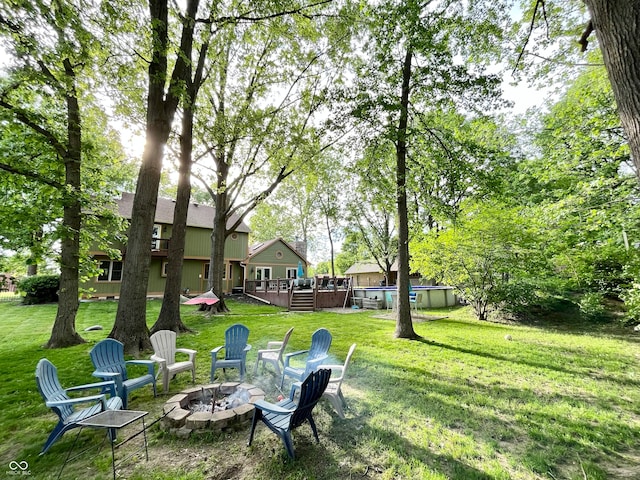 view of yard featuring a pool side deck and an outdoor fire pit