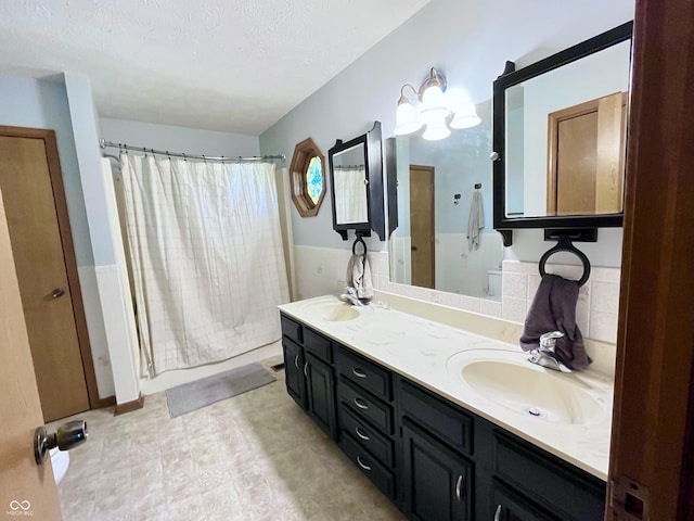 bathroom featuring curtained shower, vanity, and a textured ceiling