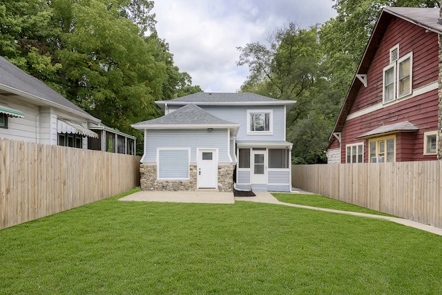 rear view of house featuring a yard