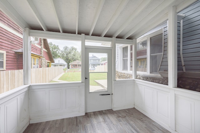 unfurnished sunroom featuring beamed ceiling