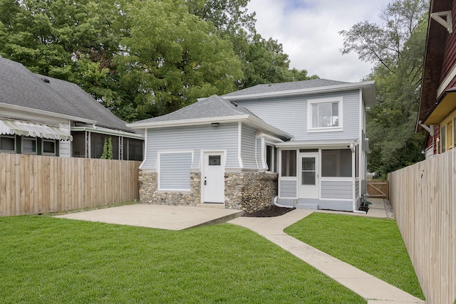 rear view of property with a lawn