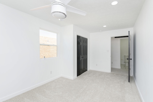 unfurnished bedroom with ceiling fan, a closet, and light carpet