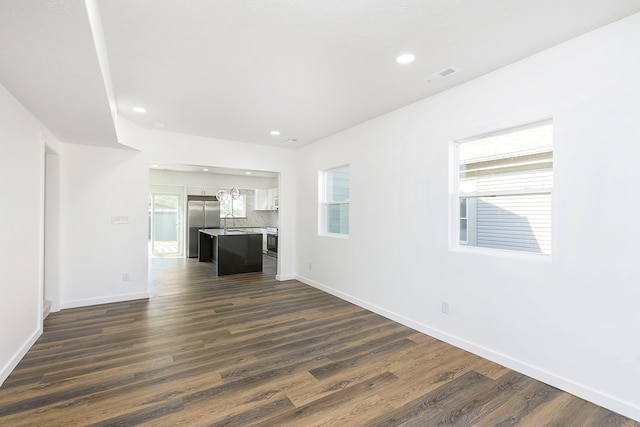 unfurnished living room with plenty of natural light, dark hardwood / wood-style flooring, and sink