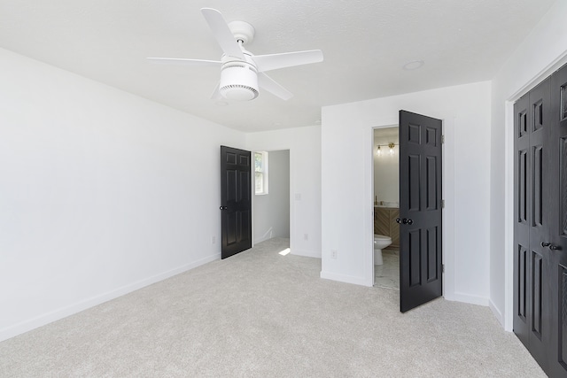 unfurnished bedroom with ensuite bath, ceiling fan, and light colored carpet