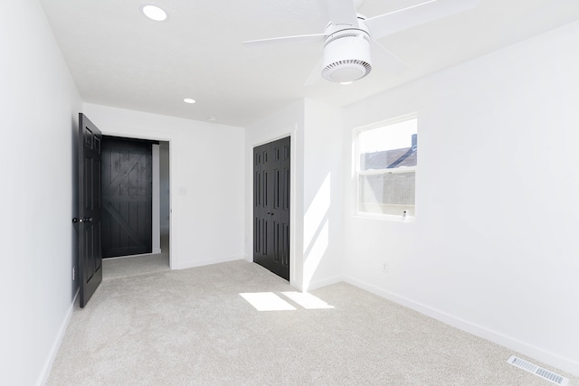 spare room featuring ceiling fan and light colored carpet