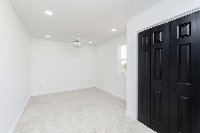 carpeted entryway with ceiling fan