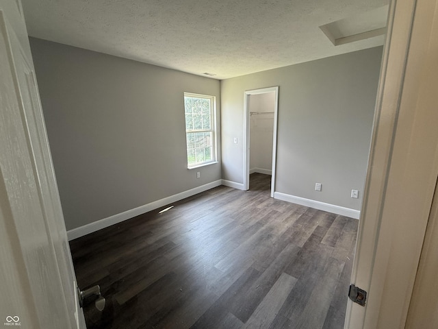 17902 Cristin Way, Westfield, IN 46062 - unfurnished bedroom with attic access, dark wood-style flooring, a textured ceiling, a walk in closet, and a closet