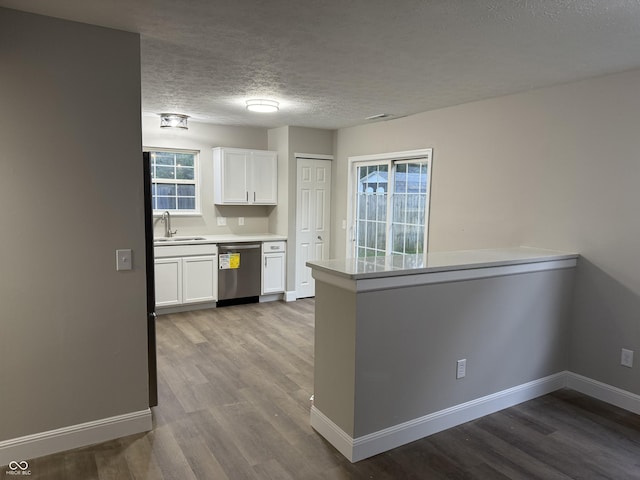 17902 Cristin Way, Westfield, IN 46062 - kitchen with stainless steel dishwasher, white cabinets, wood finished floors, a textured ceiling, and plenty of natural light
